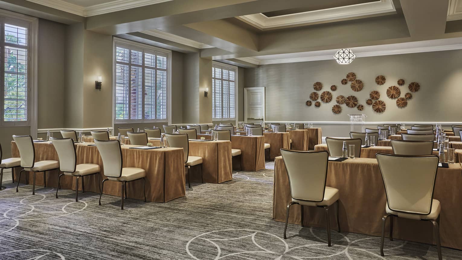 Palm Room conference, rows of meeting tables and chairs facing decorative wall