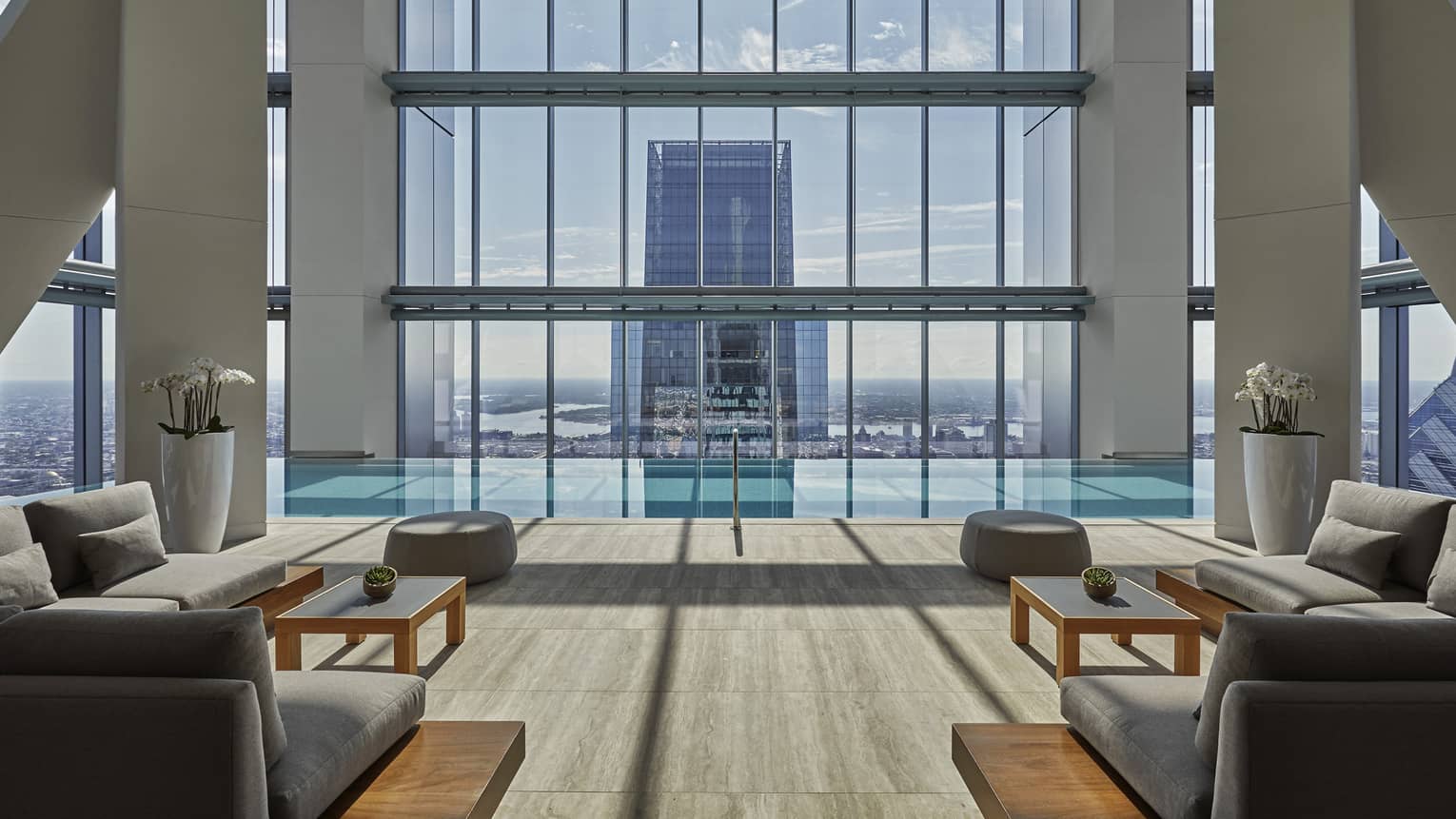 Lounge sofas in front of spa pool under tall window