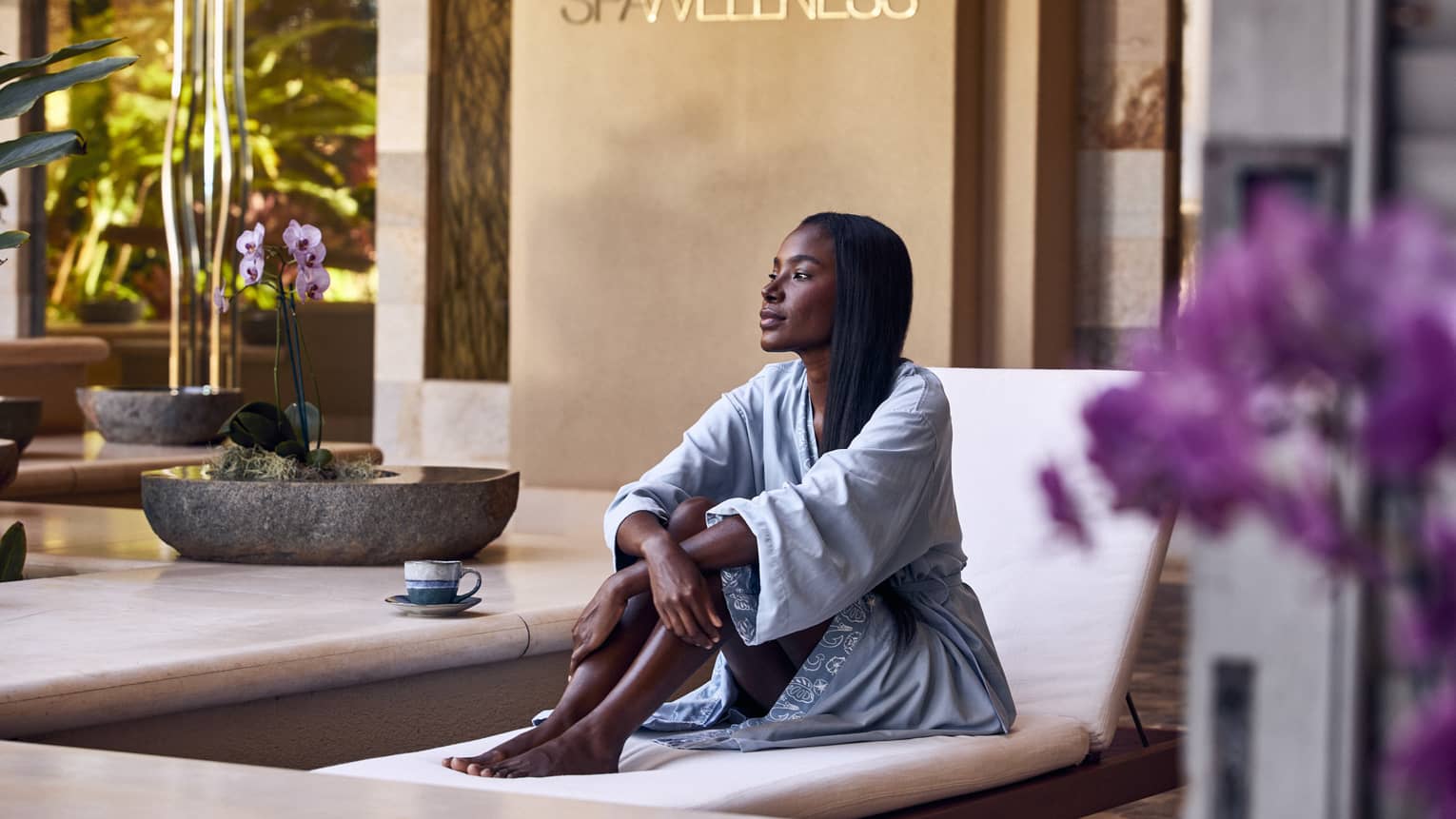 A woman sitting on a lounge chair in a spa.