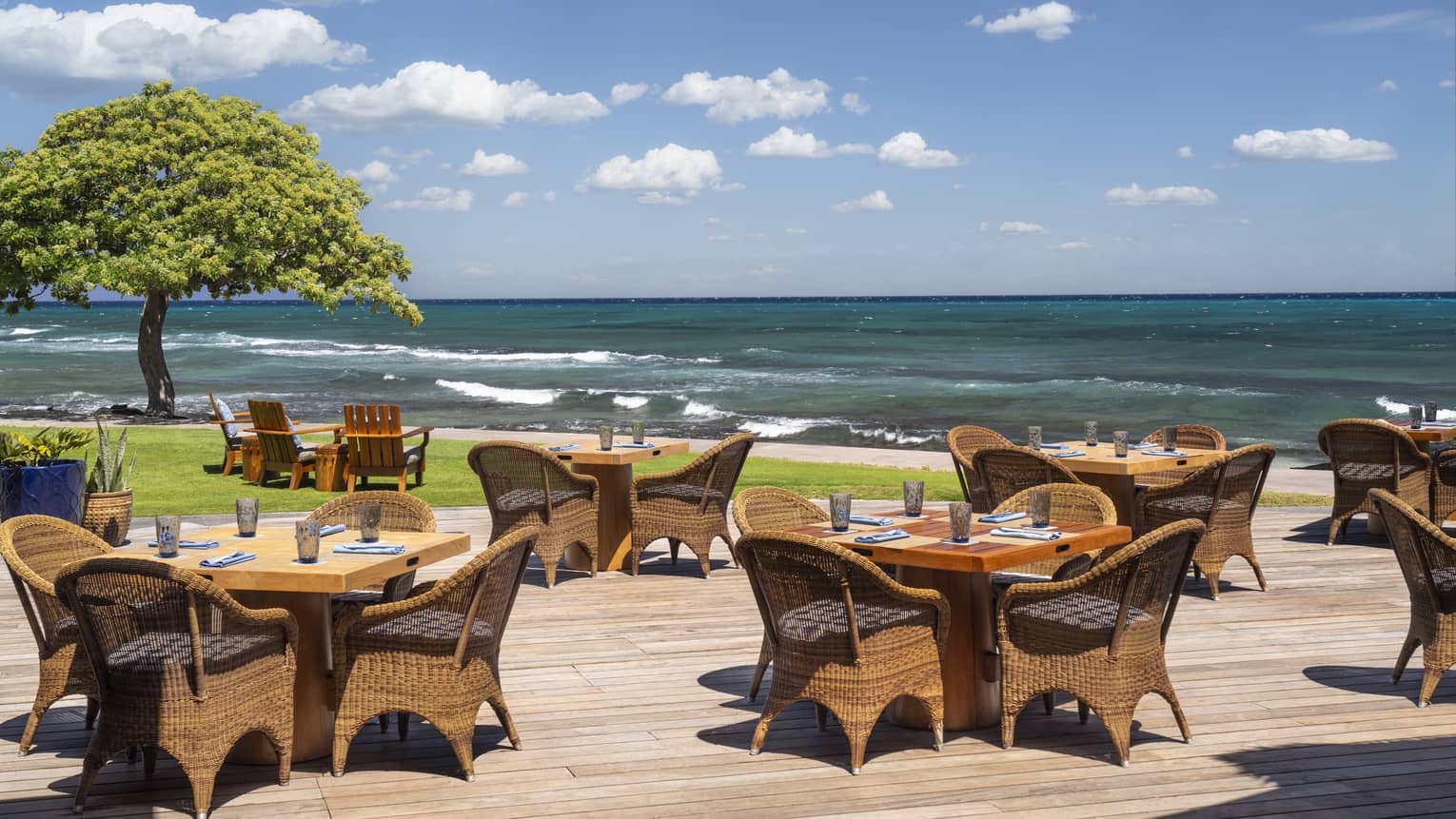 Restaurant wooden terrace with tables next to the ocean