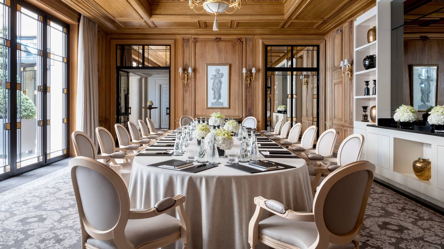 Long dining table, chairs in bright Napoléon meeting room with large windows
