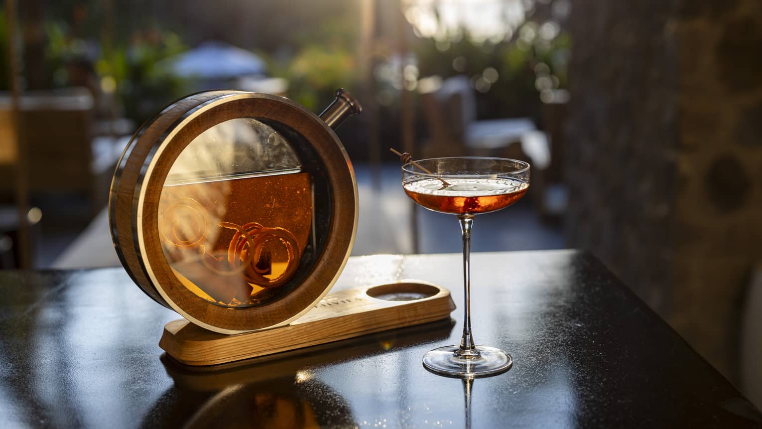 Cocktail in a coupe glass served next to a circular carafe