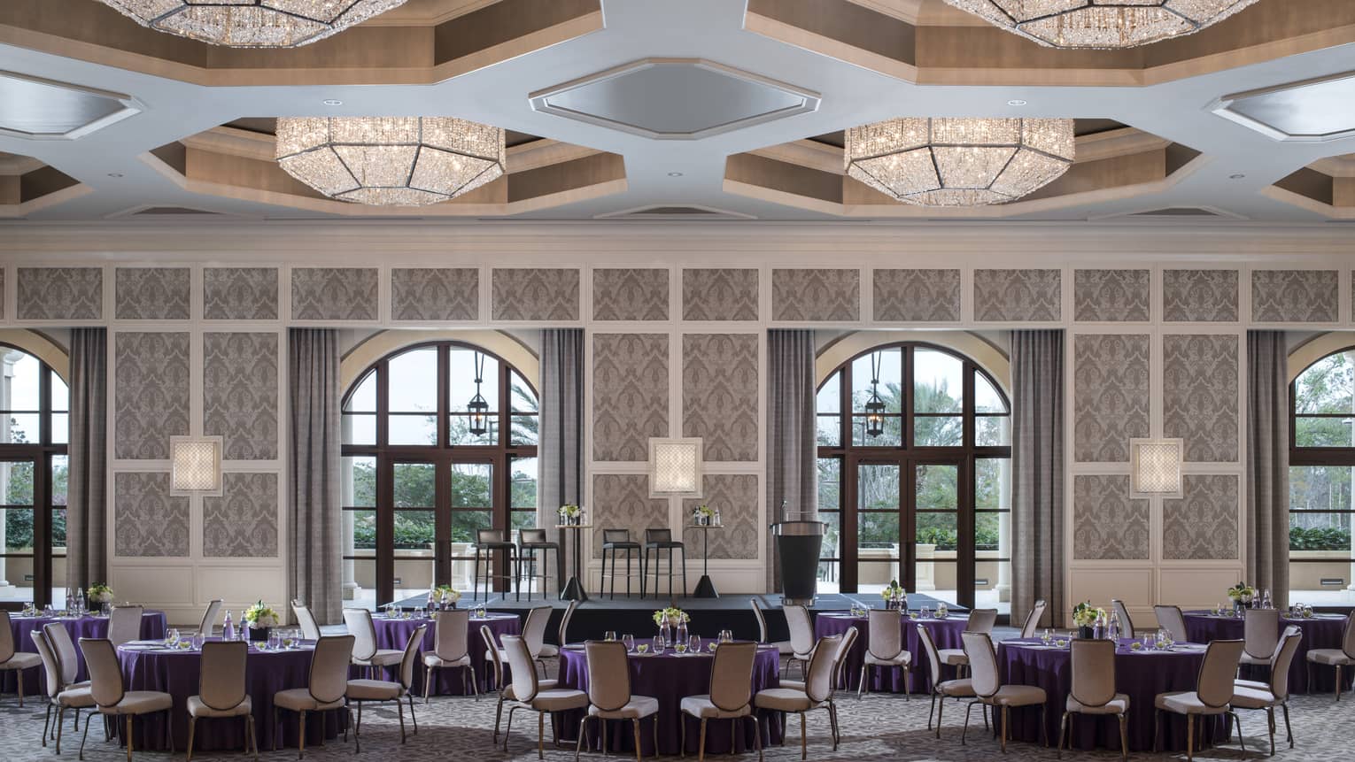 A ballroom at four seasons resort orlando at walt disney world is ready for guests with circular tables covered in purple table cloths