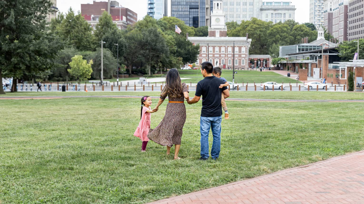 A family of four standing in a park in a city.