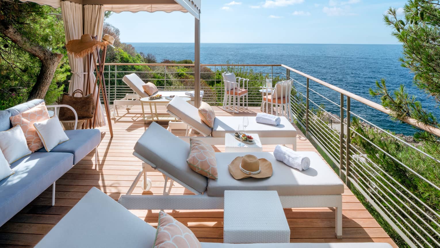 Club Dauphin private cabana terrace with white settee and lounge chairs, sea view