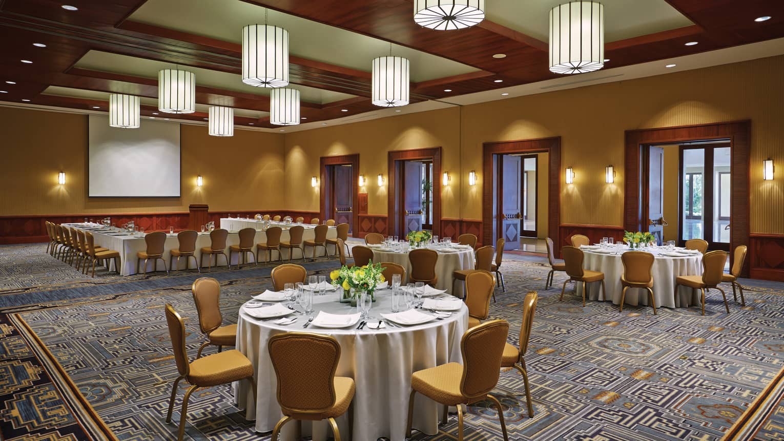 Small banquet dining tables in spacious Toki ballroom with wood accents