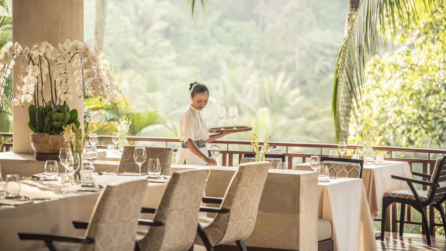 Hotel staff sets restaurant table in Ayung Terrace