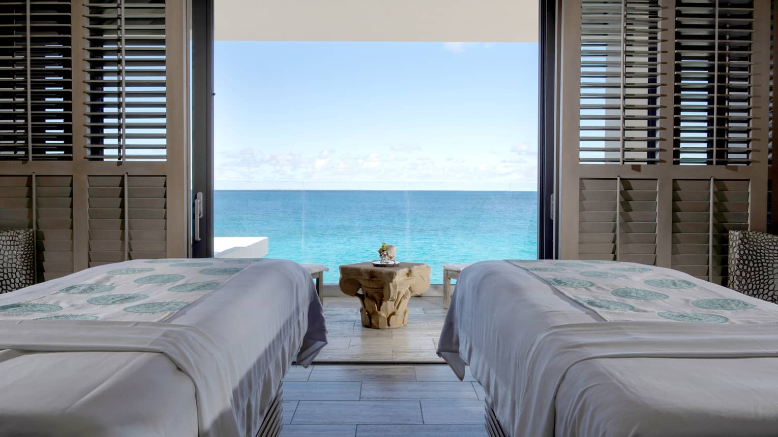 Couples massage beds in private spa cabana looking out at the ocean