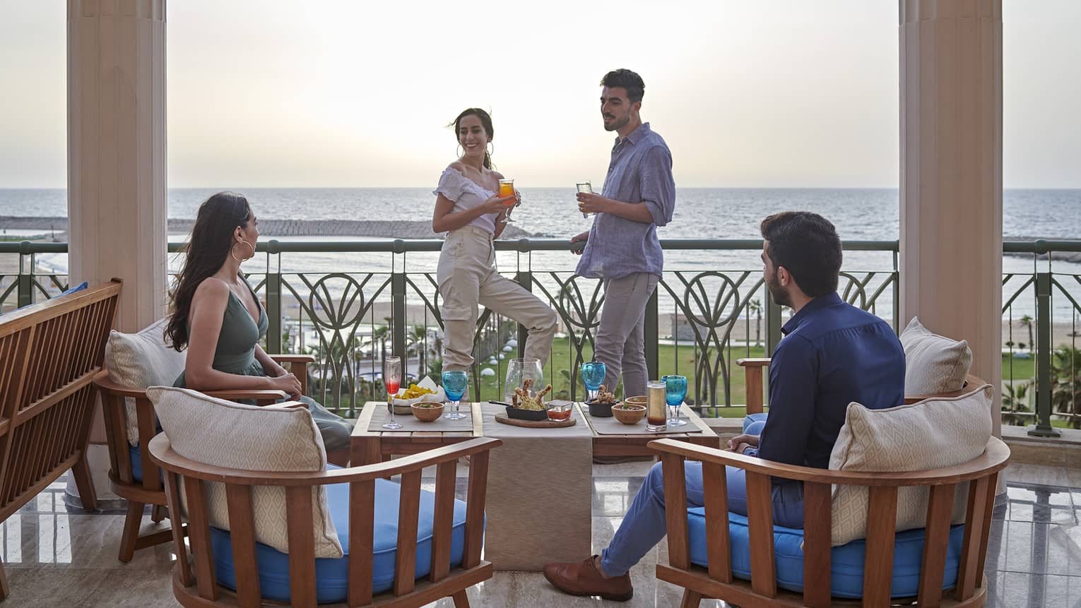 Two couples lounge on a terrace overlooking the ocean at four seasons alexandria