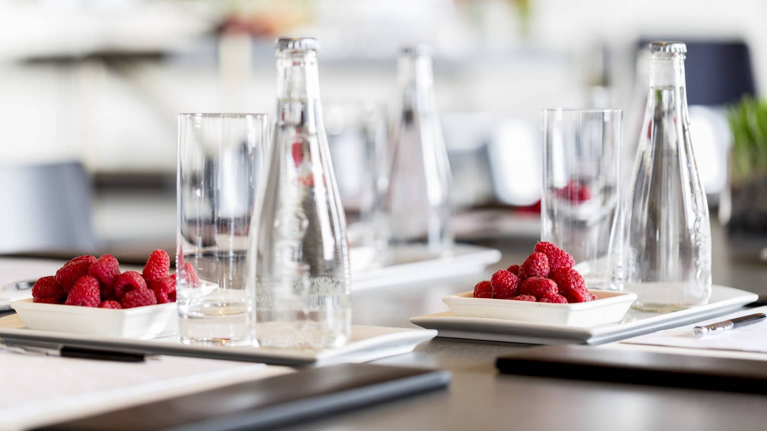 A detail from a meeting – clear glasses and red raspberries on a dark wooden table at Four Seasons Atlanta