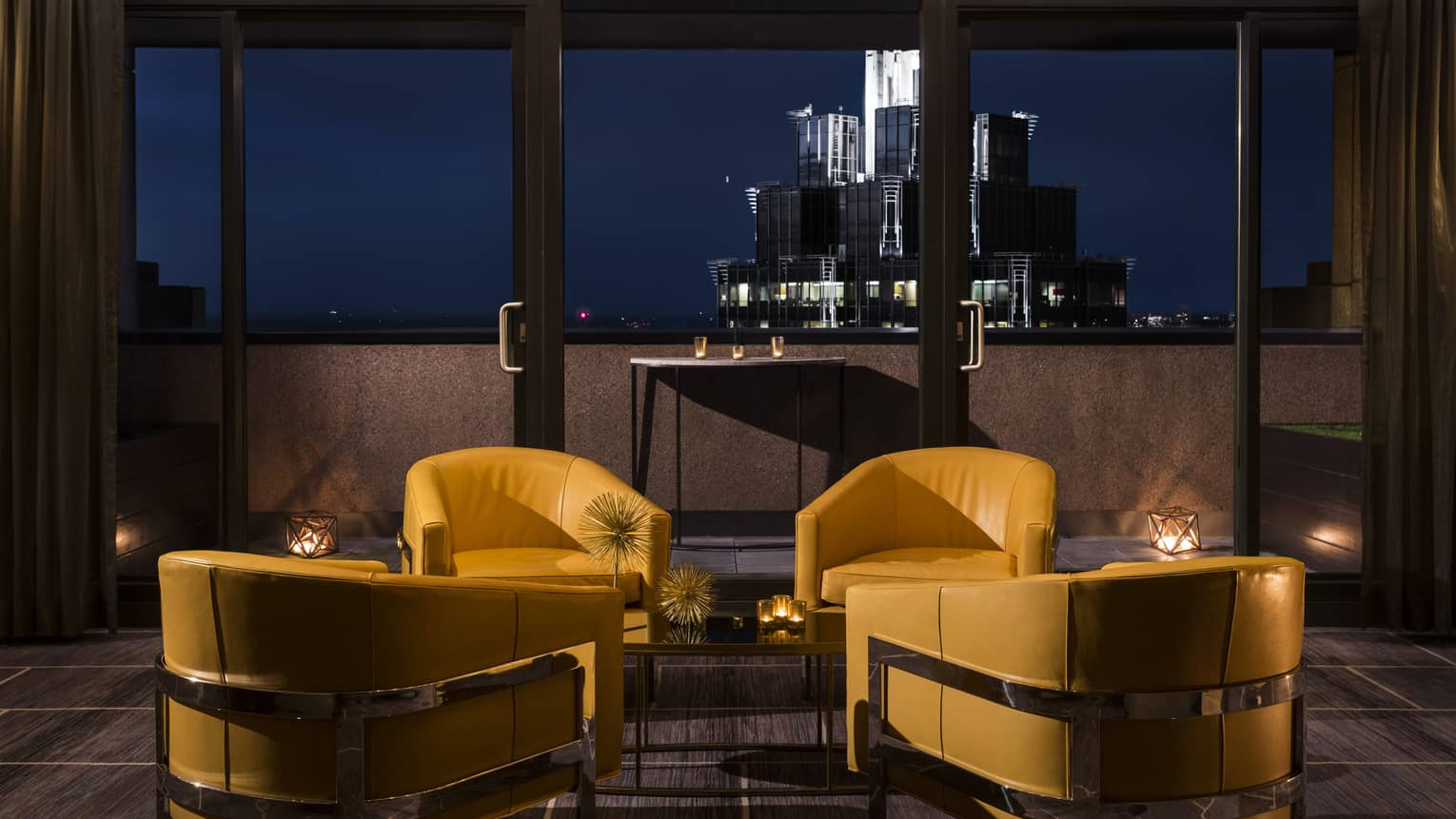 Yellow leather lounge chairs at dusk, the cityscape in the background 