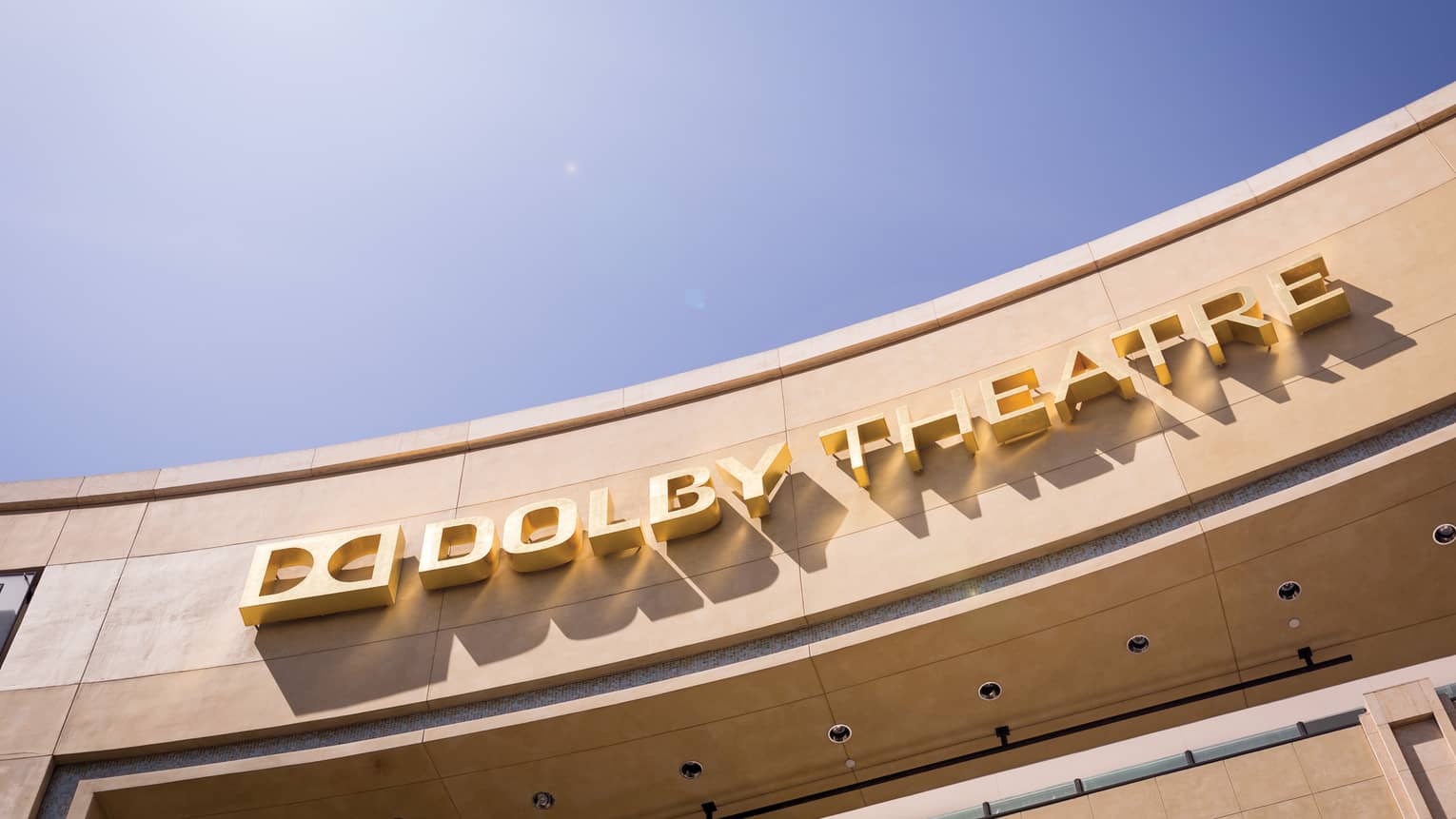 Curved Dolby Theatre sign against sunny blue sky