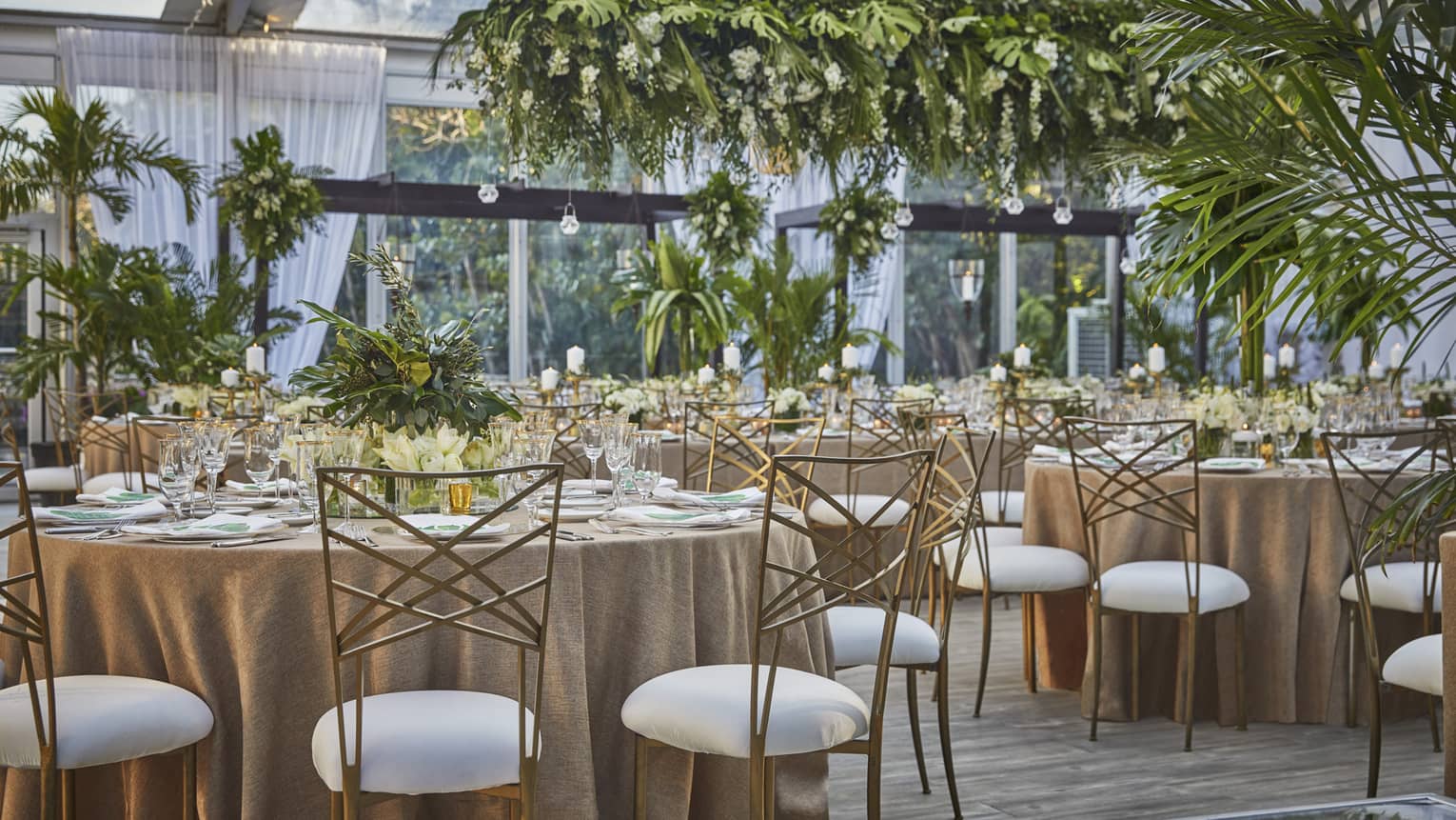 Wedding banquet, round dining tables with tropical greenery