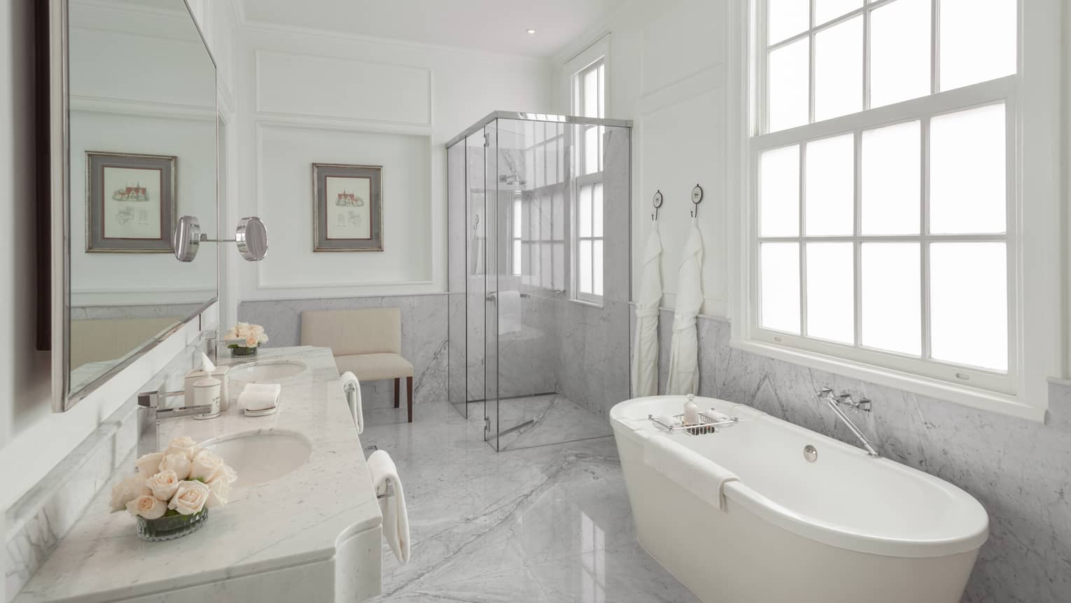 The La Mansion Bathroom is filled with a porcelain bath tub, glass shower and long mirror