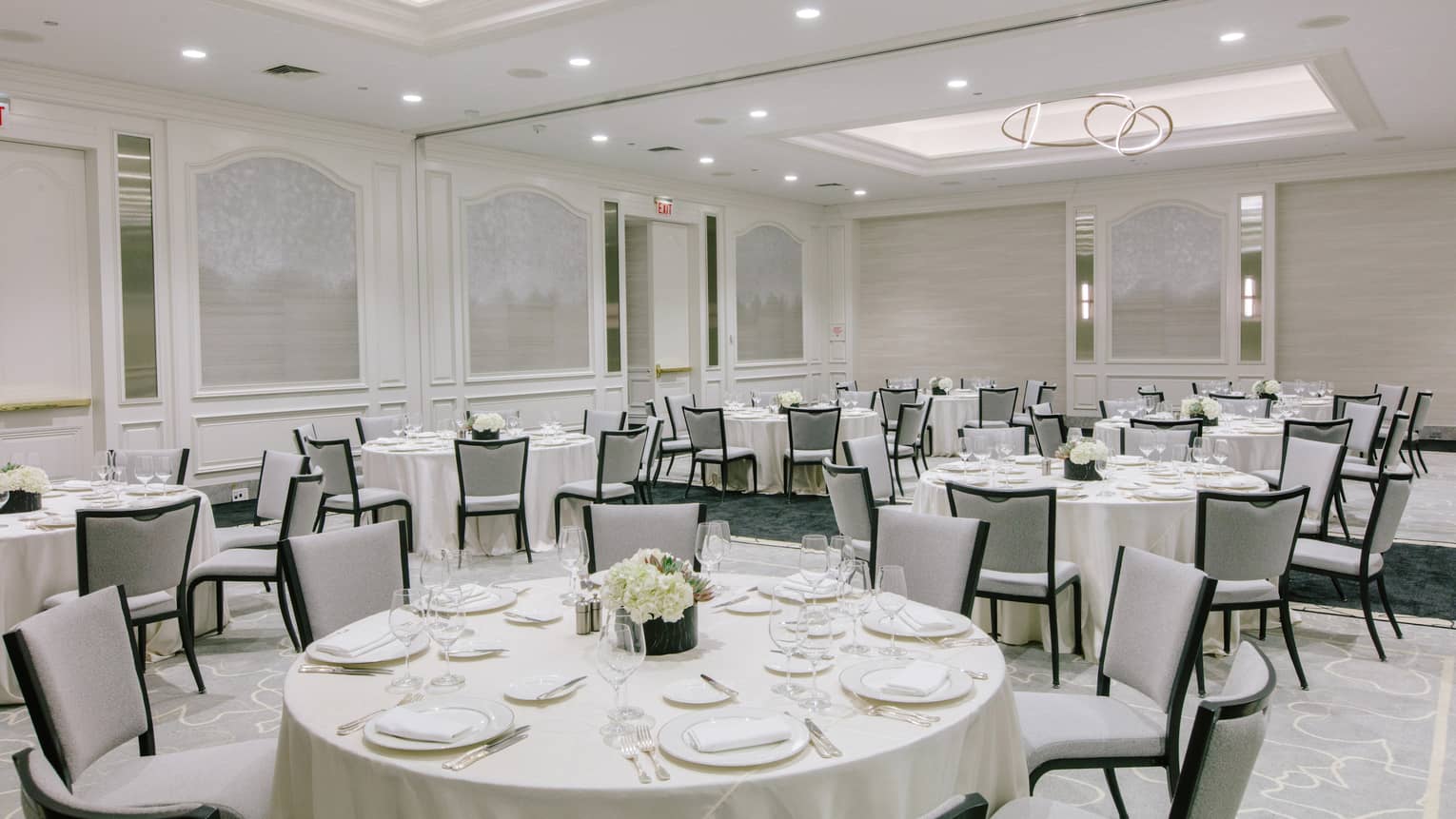 A large room with round tables covered in white cloth.