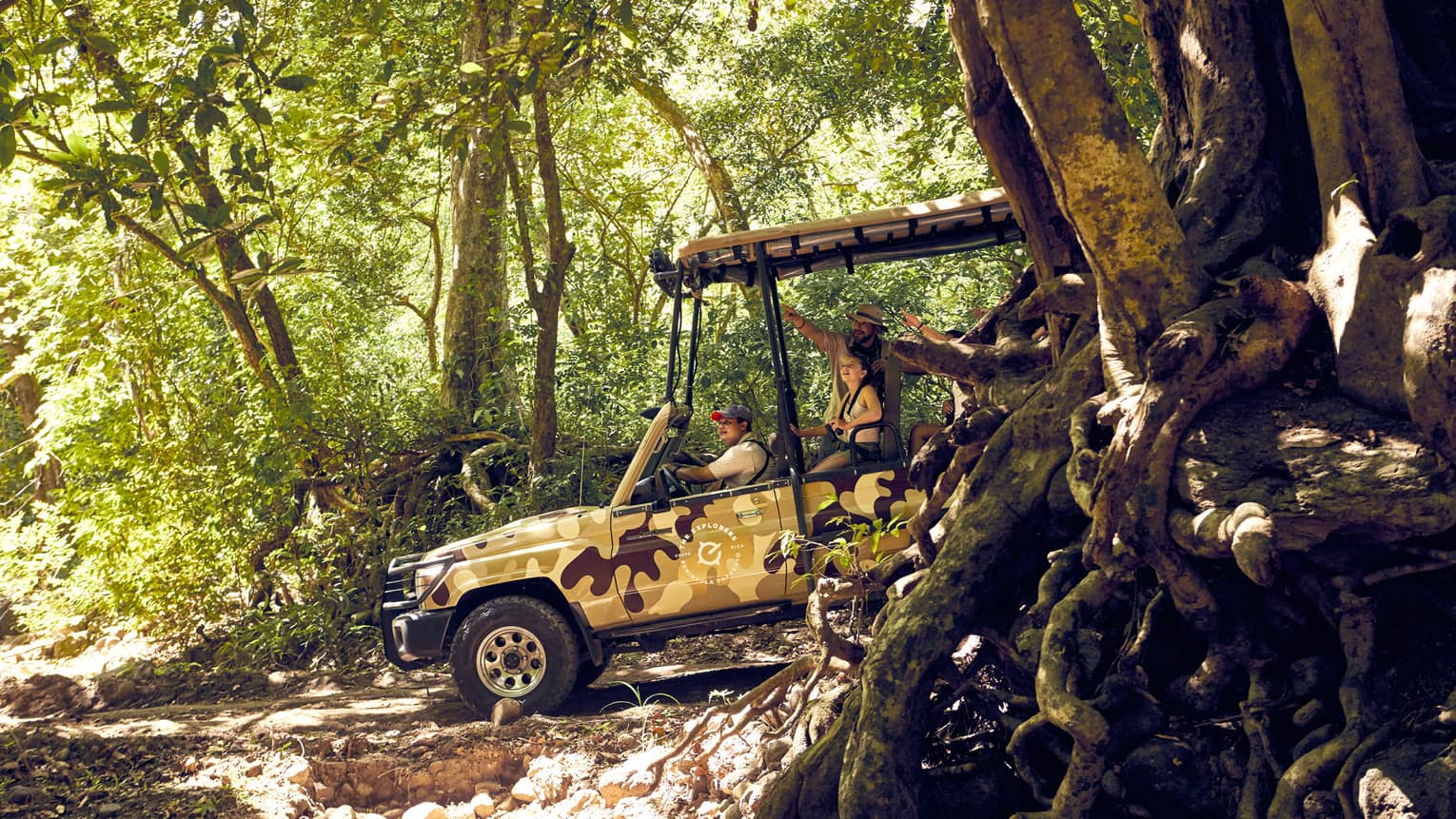 A tour guide and two guests explore the Costa Rican jungle in an open-air Jeep