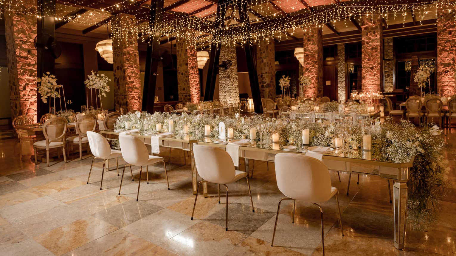 Ornately decorated function room arranged banquet style with stone pillars