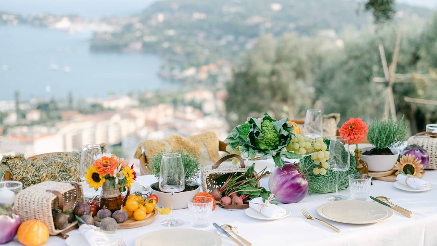 Elegantly set dining table with produce d�cor overlooking the Mediterranean Sea