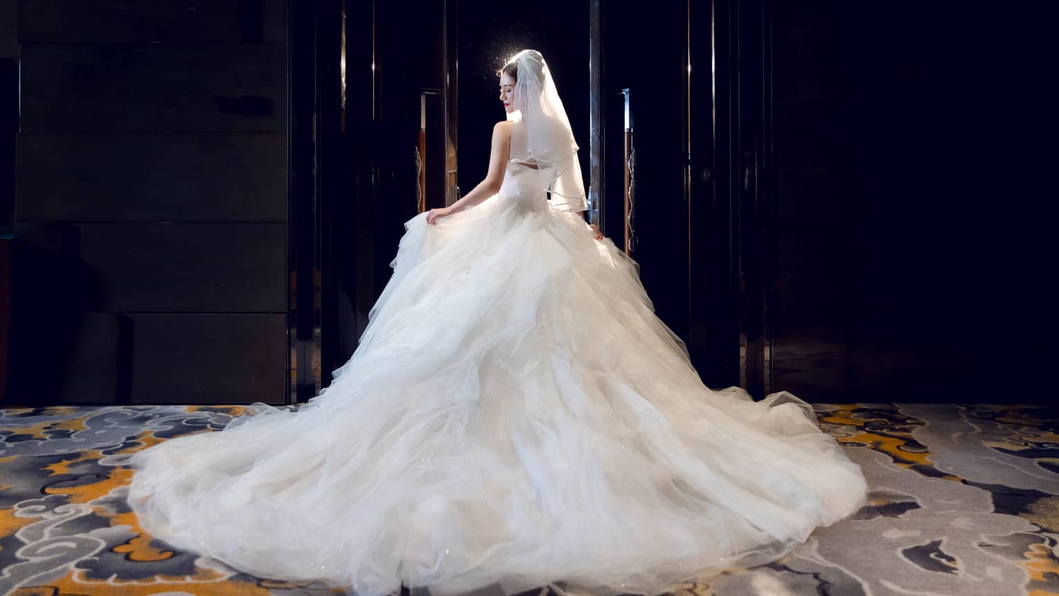 Bride in ball gown-style dress stands in the Grand Ballroom