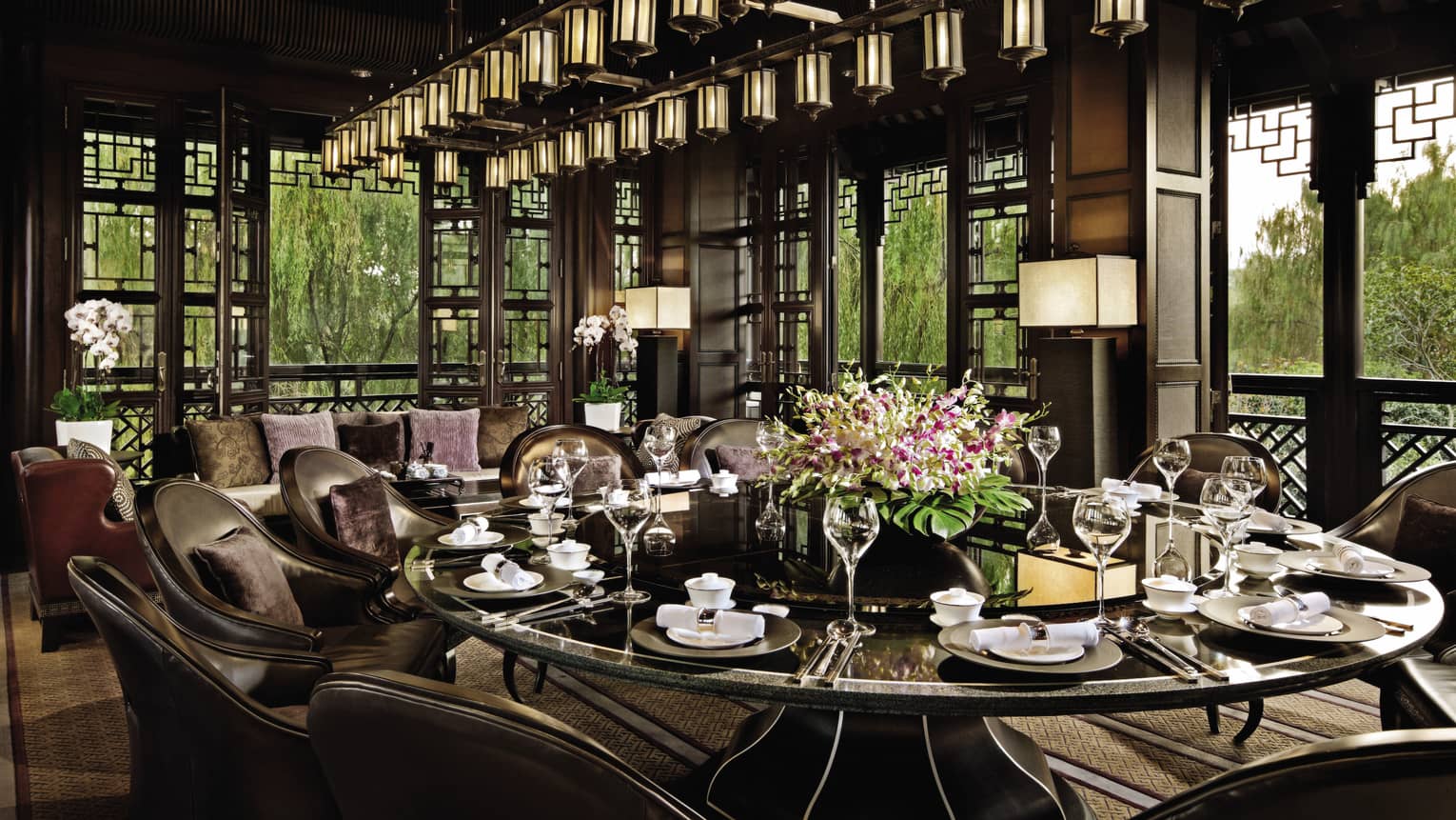 Large round, black, shiny dining table under lantern chandelier at Jin Sha