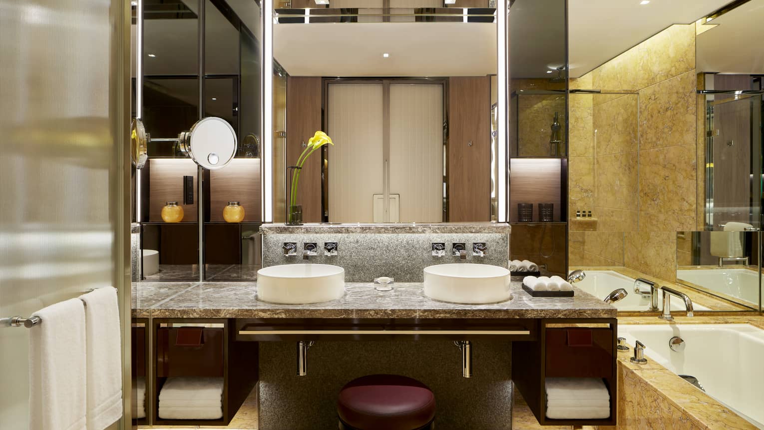 Bathroom with double vanity, tub, wall of mirrors