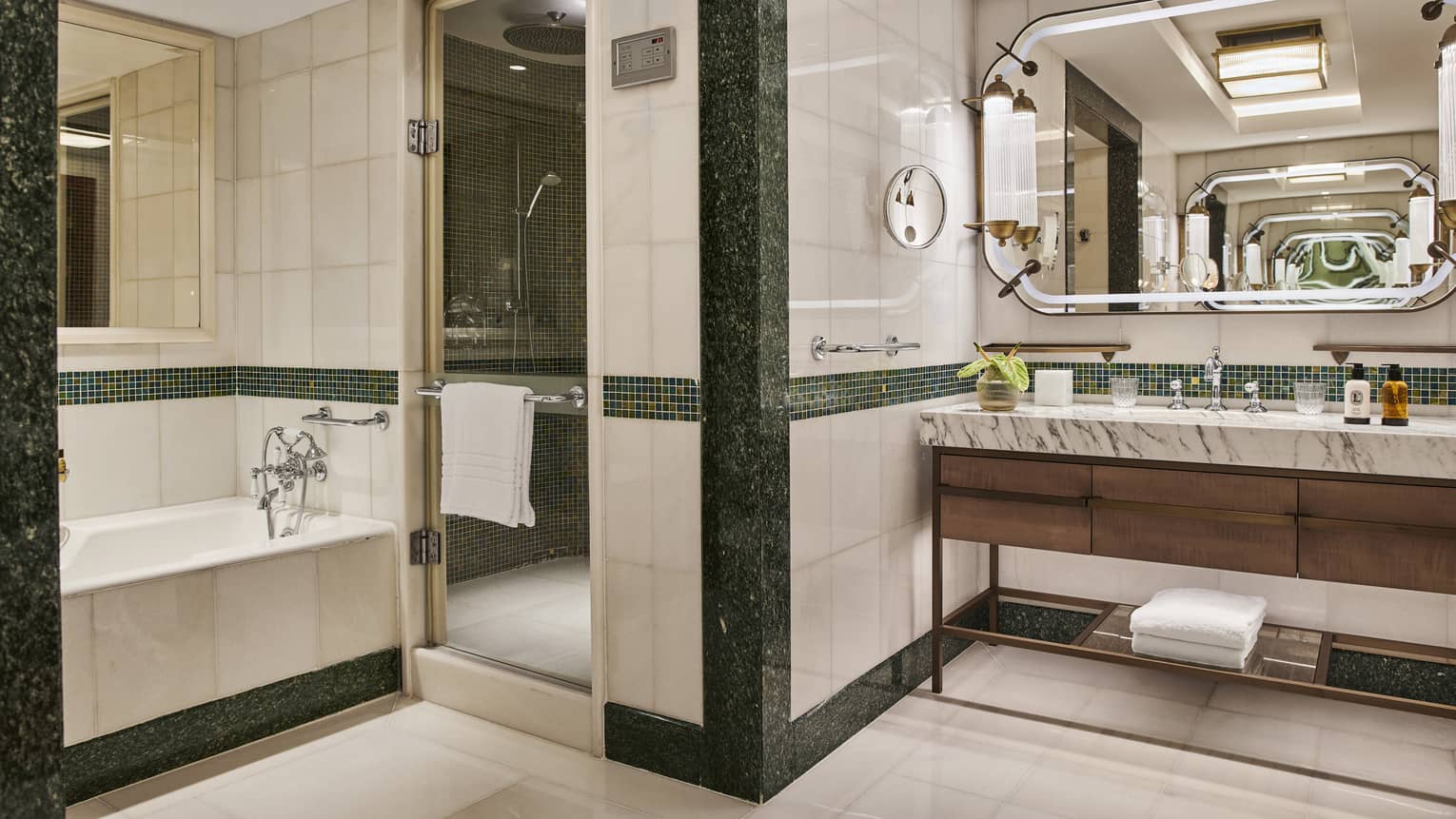 Modern full marble bathroom with soaking tub, double vanity and large mirror with sconces