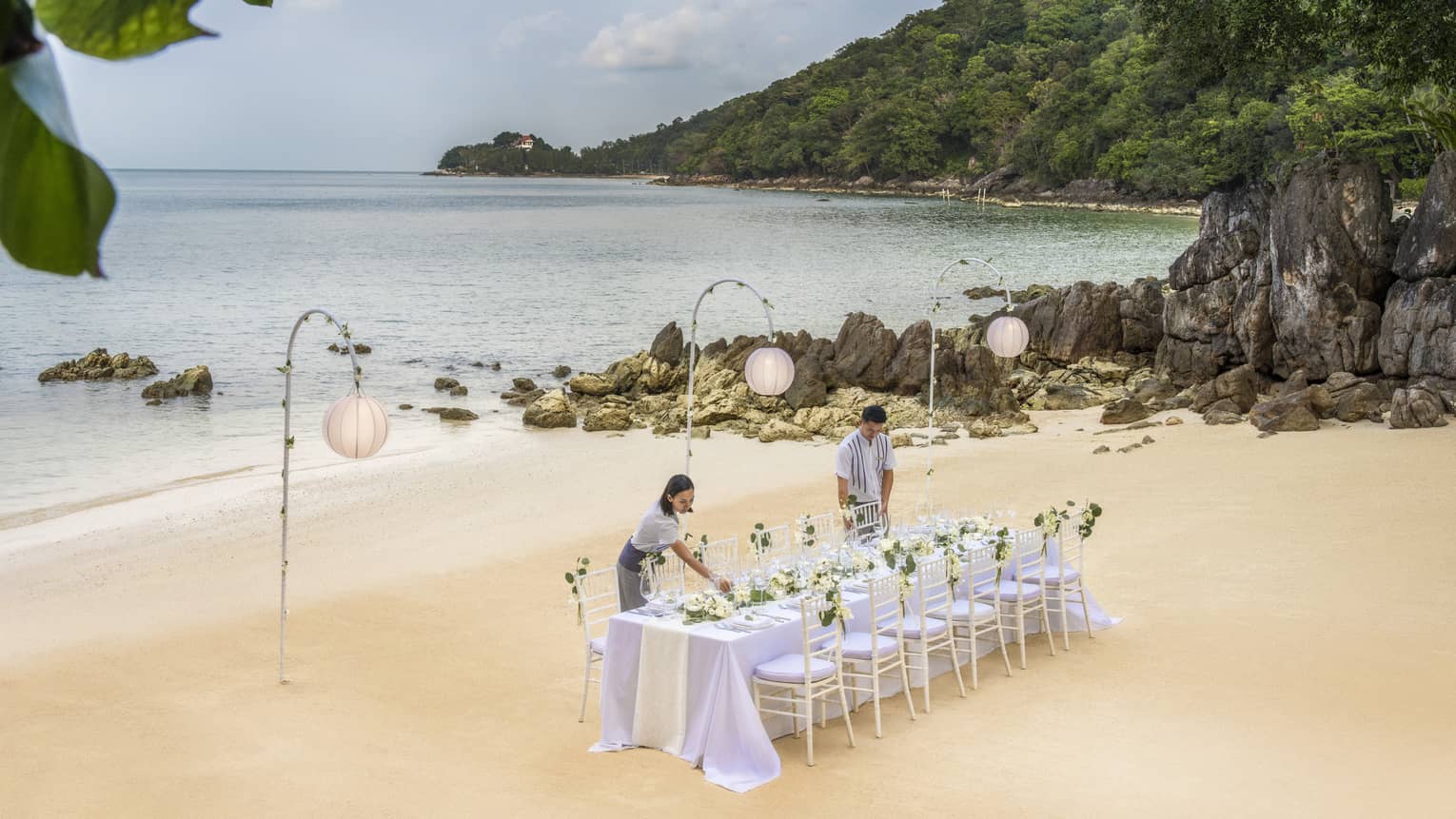 Team members set up a reception table on the beach