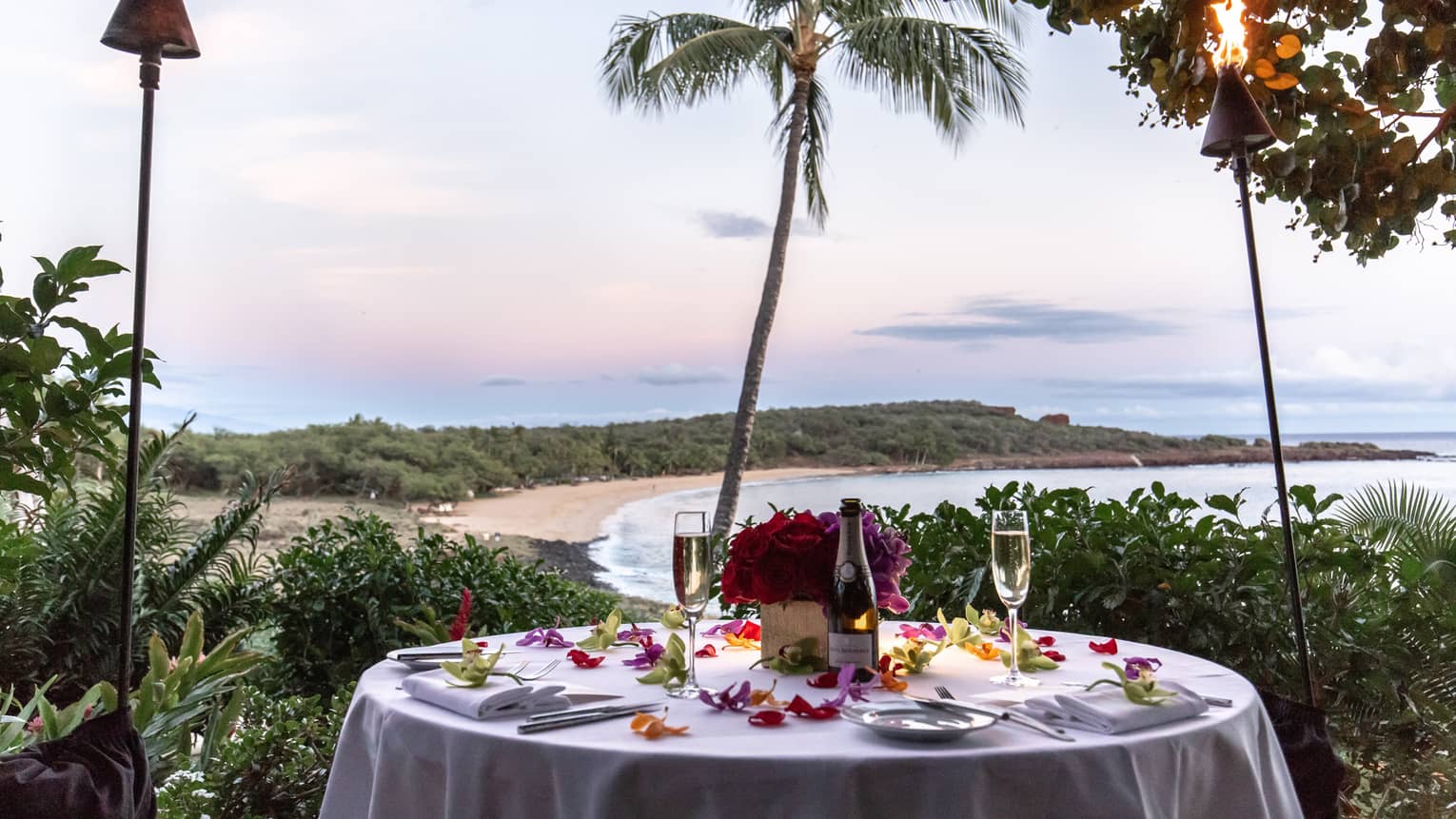 Round dining table set for two outside overlooking tropical bay