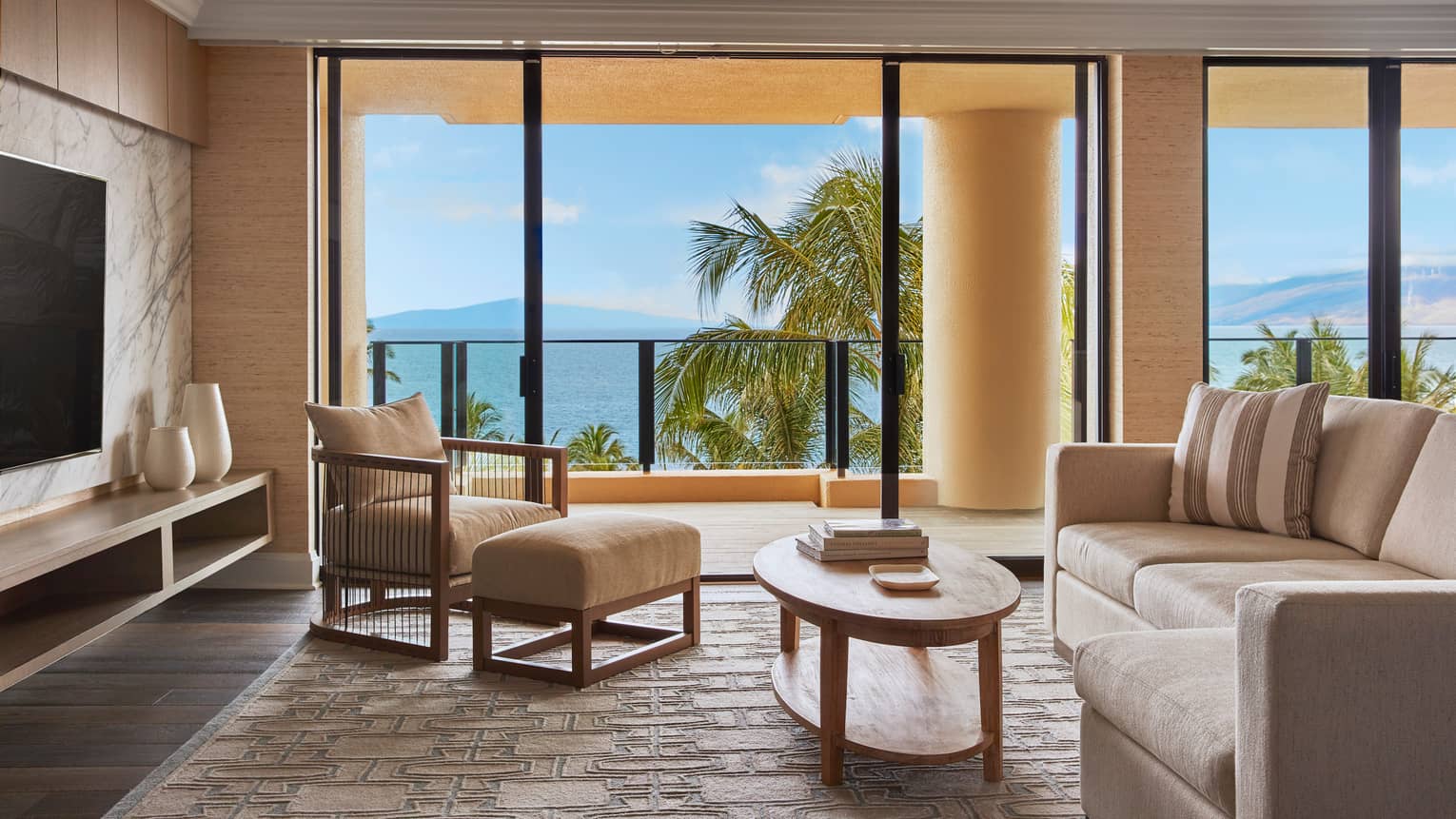 Elite Suite sitting area with doors leading out to a private terrace and a view onto the ocean