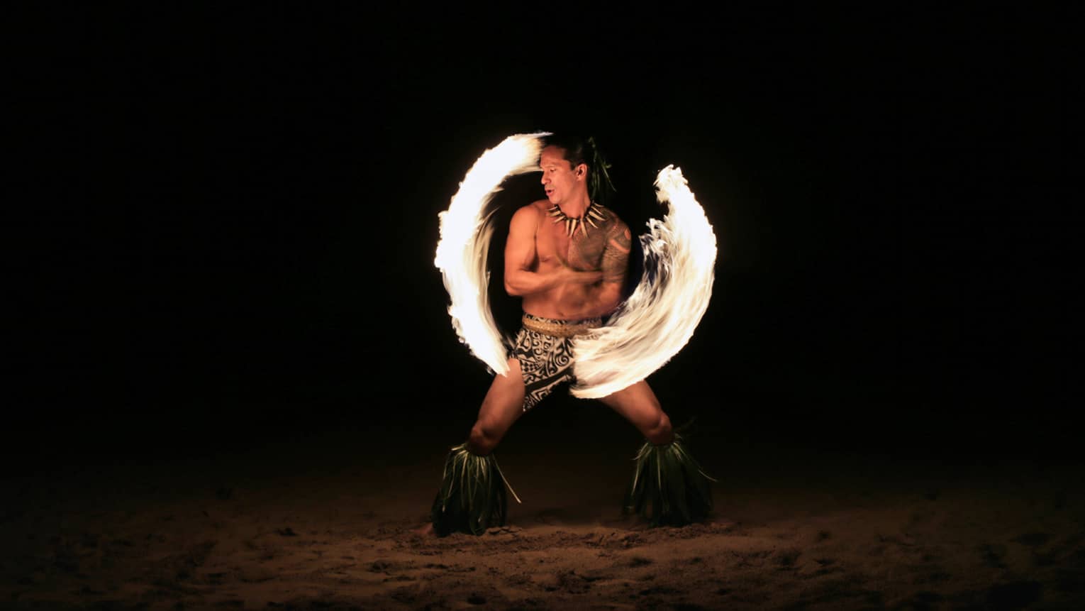 Fire dancer spins fire on the beach