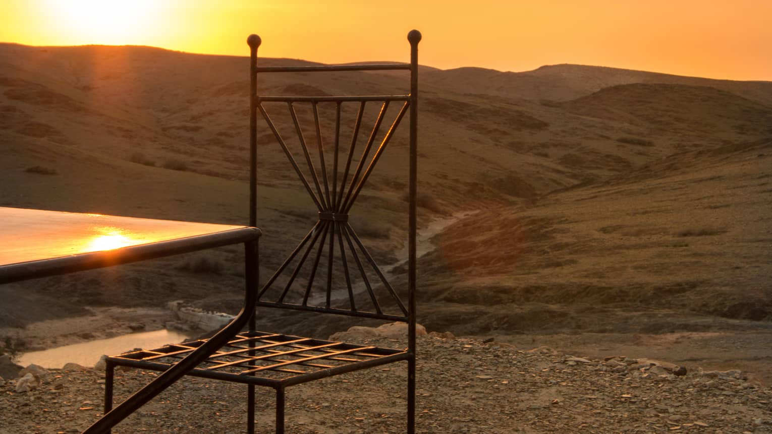 Corner of table, chair in desert at sunset