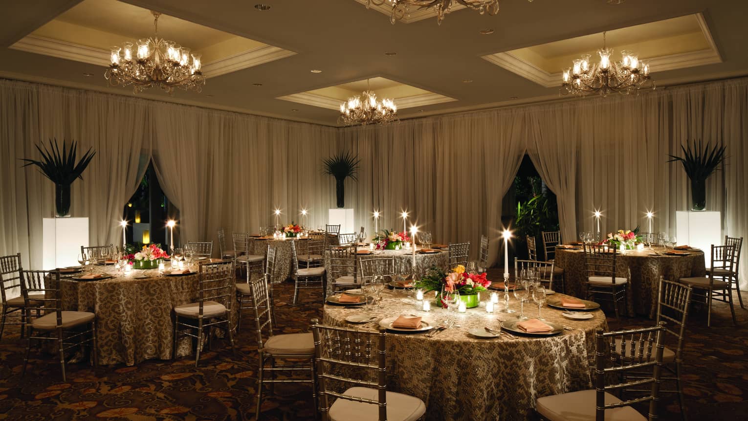 Round candle-lit banquet dining tables in ballroom