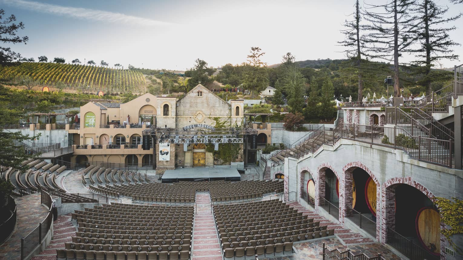 A large outdoor concert venue surrounded by old buildings and a winery.