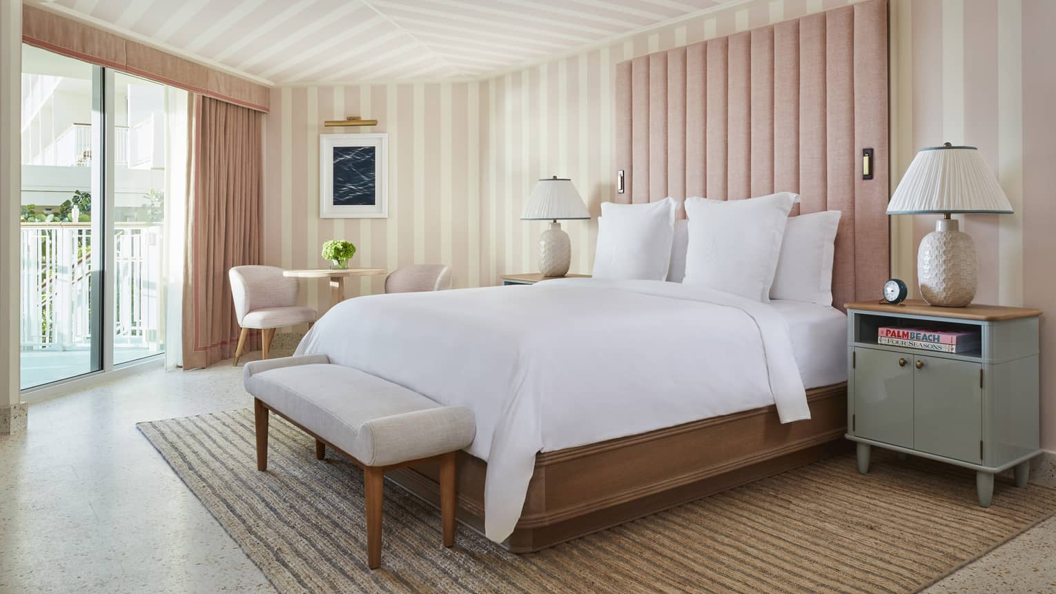 Room with walls and ceiling that have pink stripes, and a glass door.