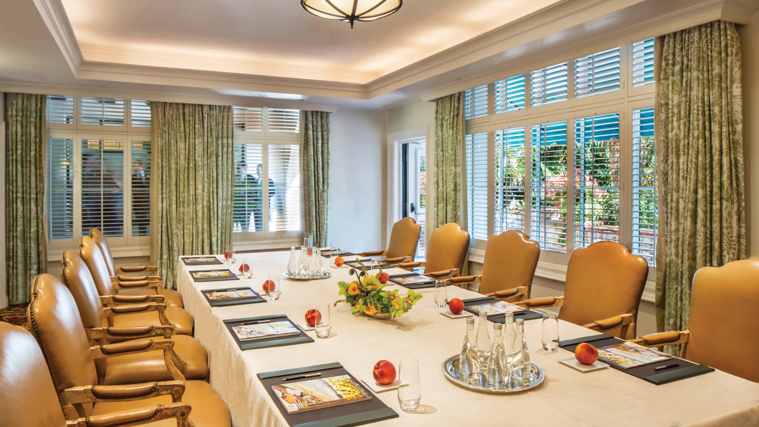 La Fonda meeting room boardroom table with large tan leather chairs, corner windows 