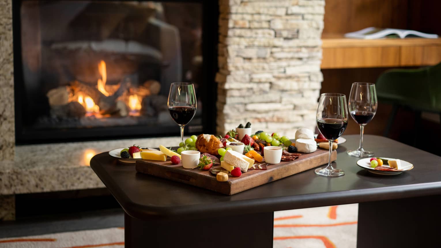 Charcuterie board, wine and living room fireplace