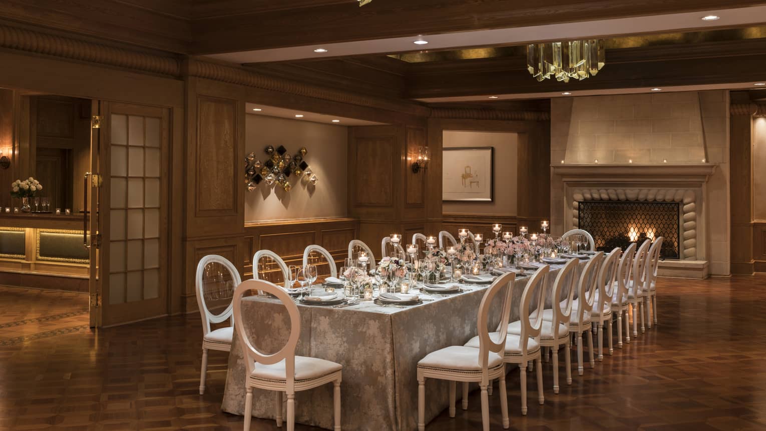 Savannah Hall banquet room with long private dining table, candles under modern crystal lights