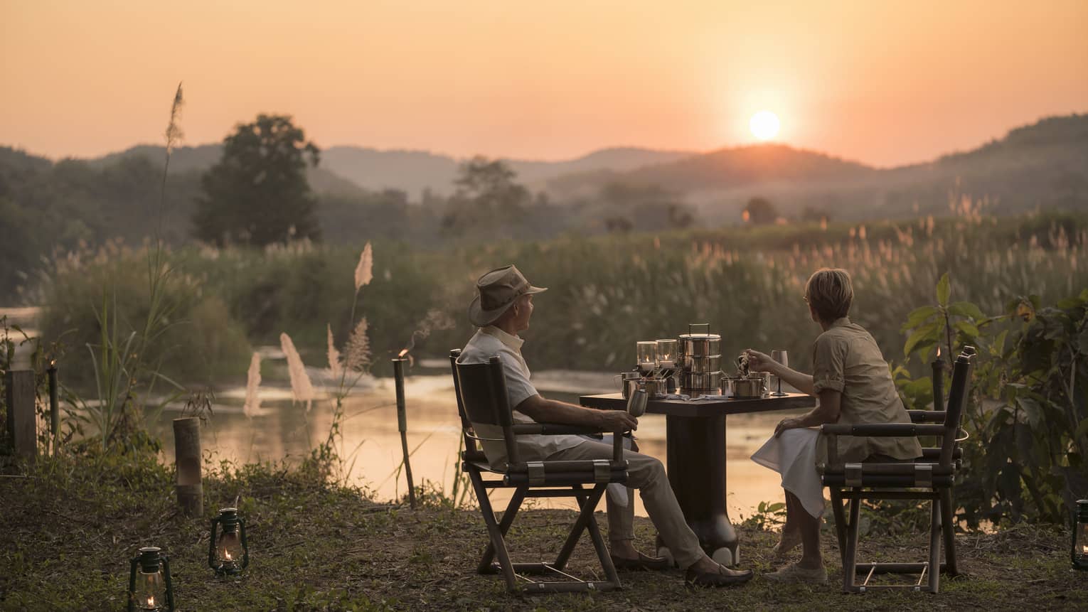 Couple enjoys Camp Bush Dinner along river at sunset
