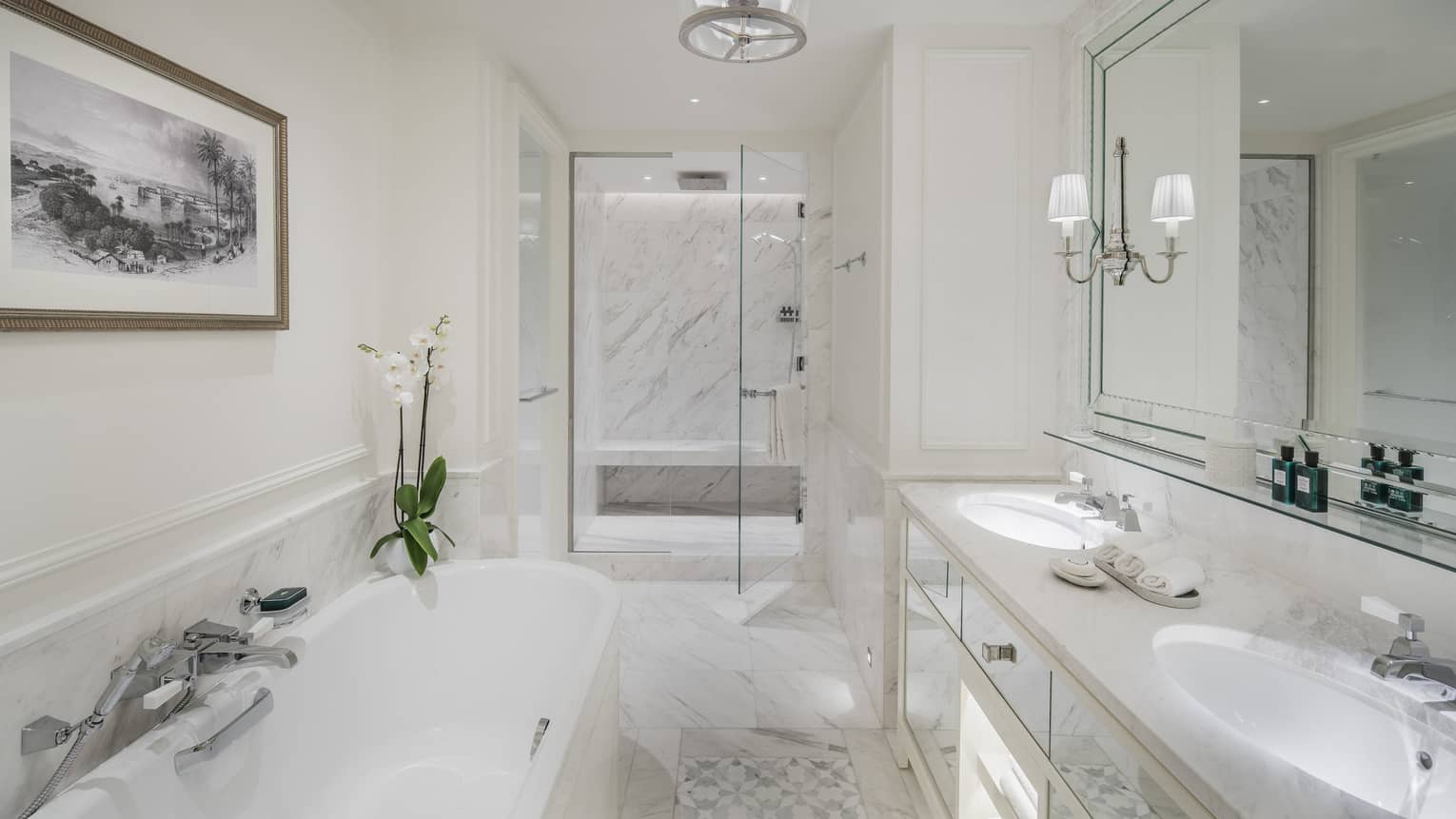 A marble bathroom with a large tub separate from a glass-walled shower.