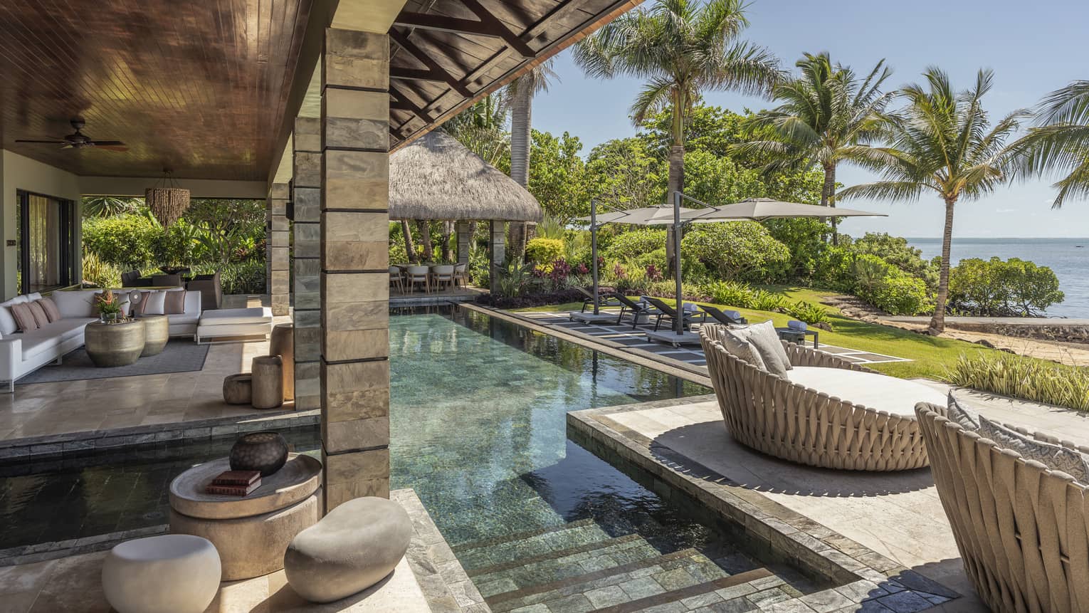 Stone, ocean-view terrace with pool, whicker day beds, pavilion covering