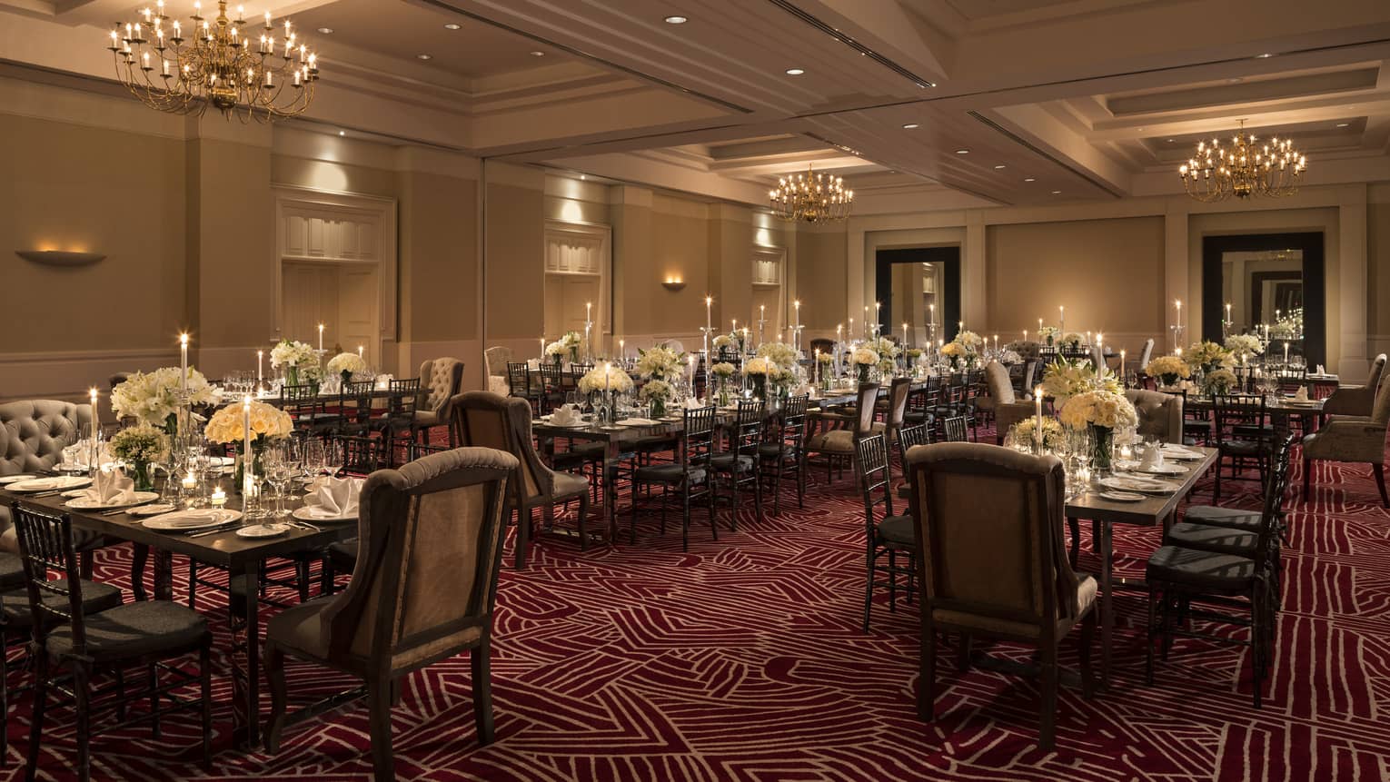 Wedding reception, dining tables with tall candles and white flowers in banquet room