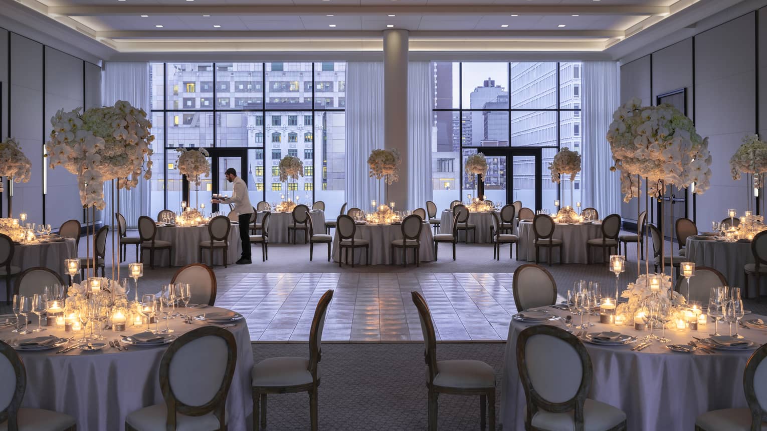 Four Seasons staff sets round table with candles in Palais des Possibles Ballroom