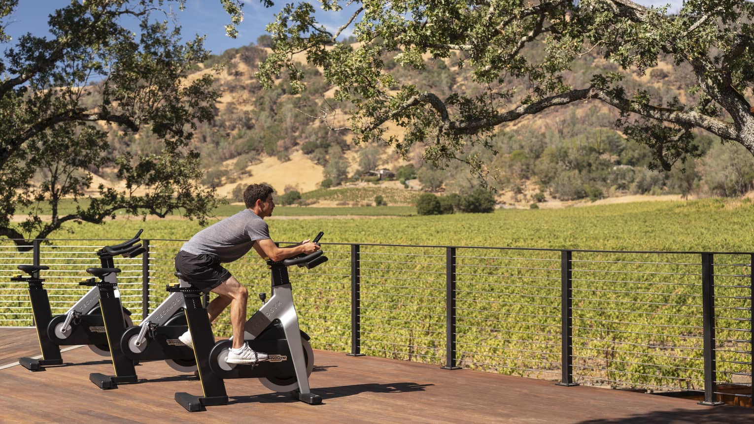 Man using a stationary bike outdoors surrounded by nature.