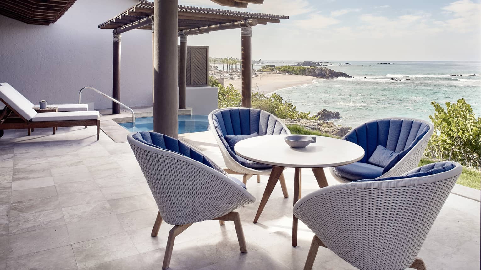 Outdoor terrace, dining table with four wicker chairs, plunge pool, ocean view