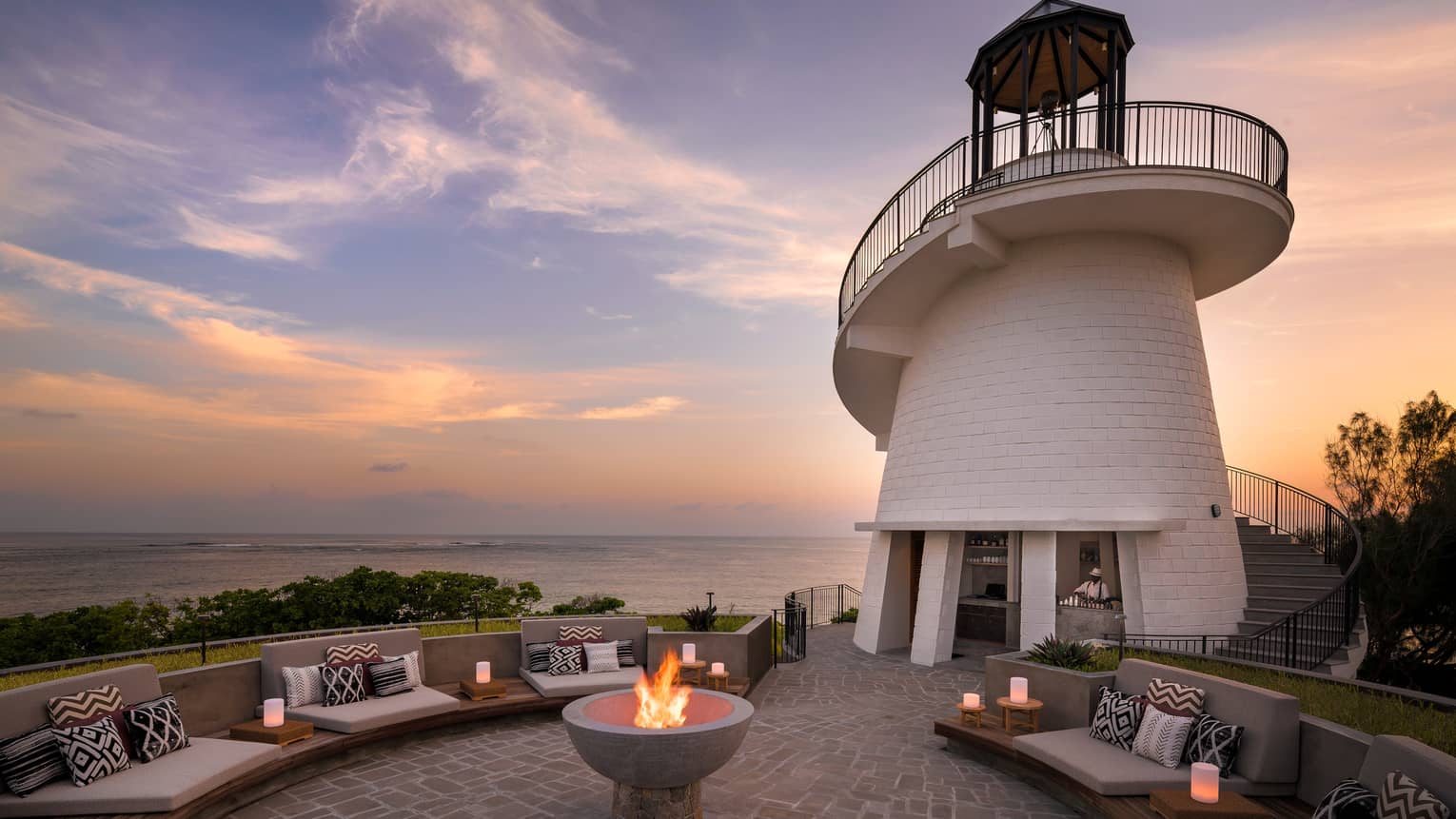 Lighthouse Restaurant illuminated at sunset with fire pit and luminaries