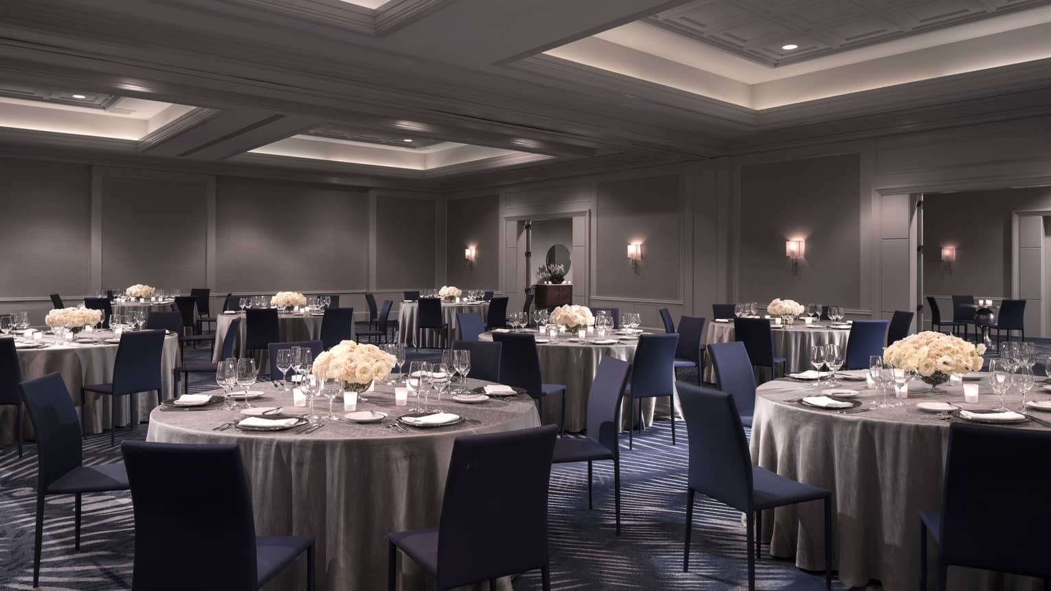 Yerba Buena event room with small round banquet tables with silver linens, chairs