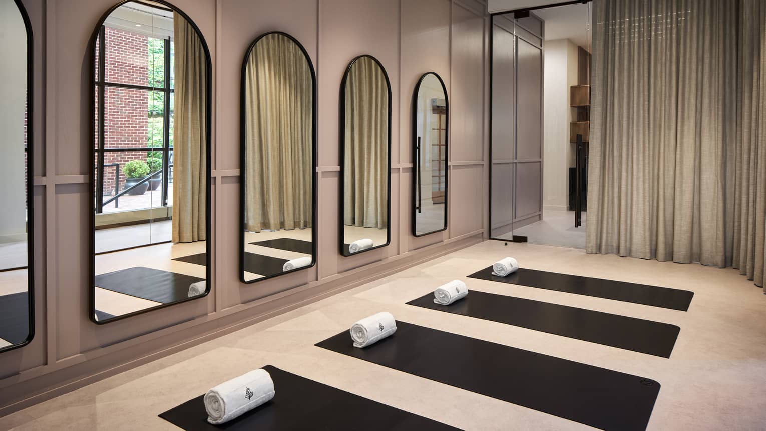 Yoga mats in a yoga studio with mirrors on the wall.