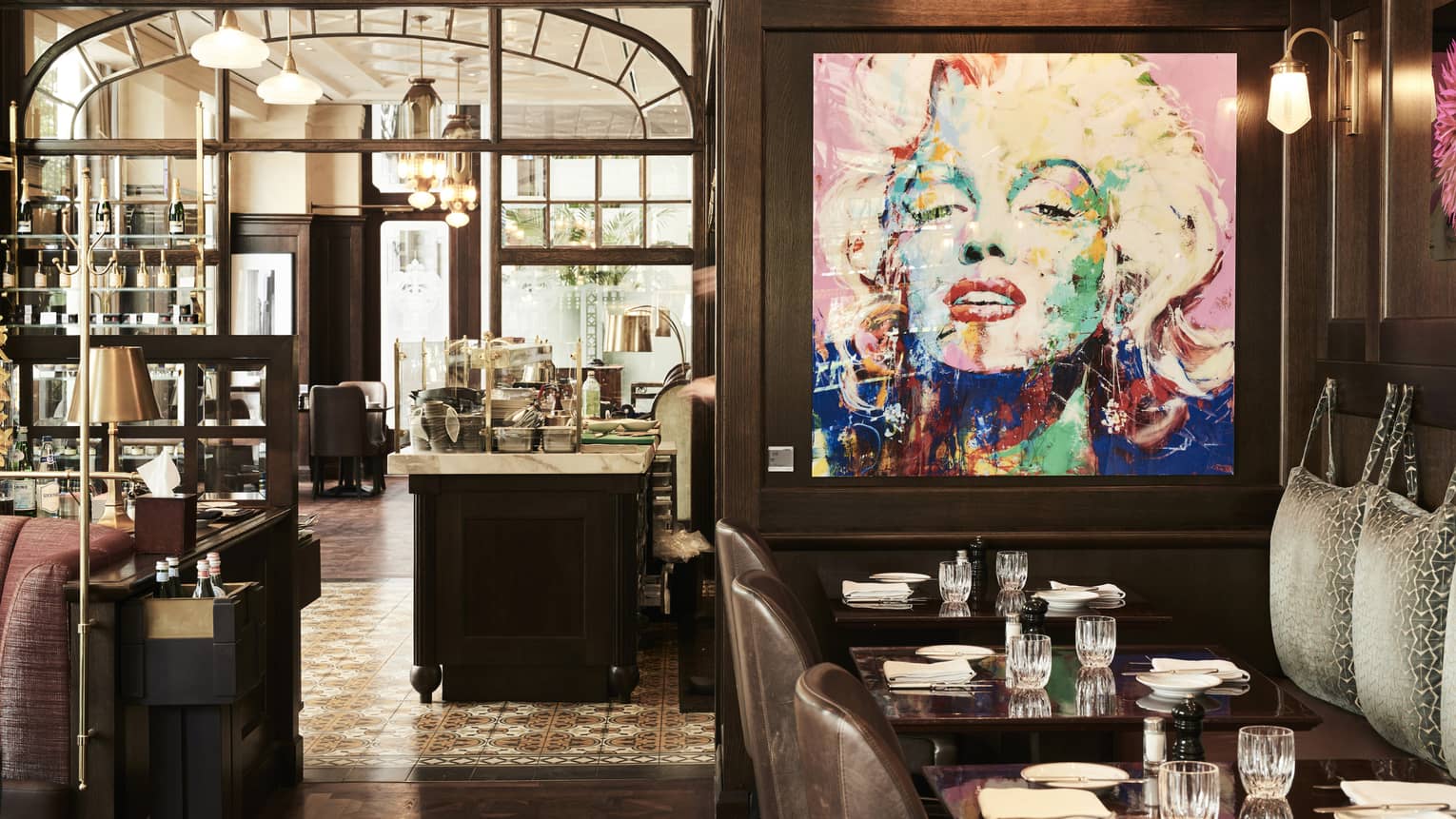 Tables in contemporary brasserie with large artwork of Marilyn Monroe 