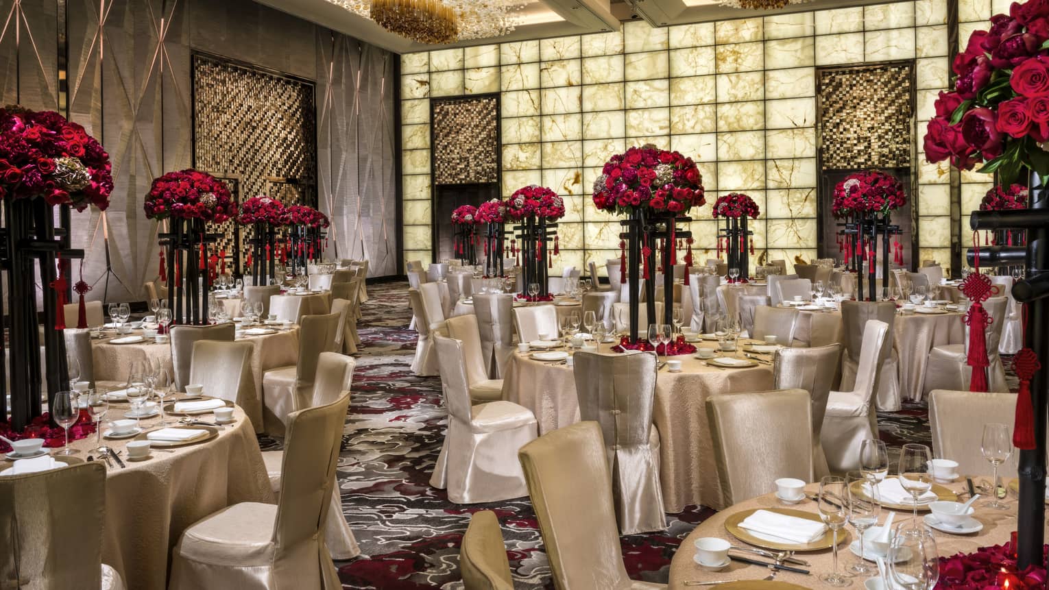 Grand Ballroom banquet tables and chairs with silk linens, red flowers in tall vases 