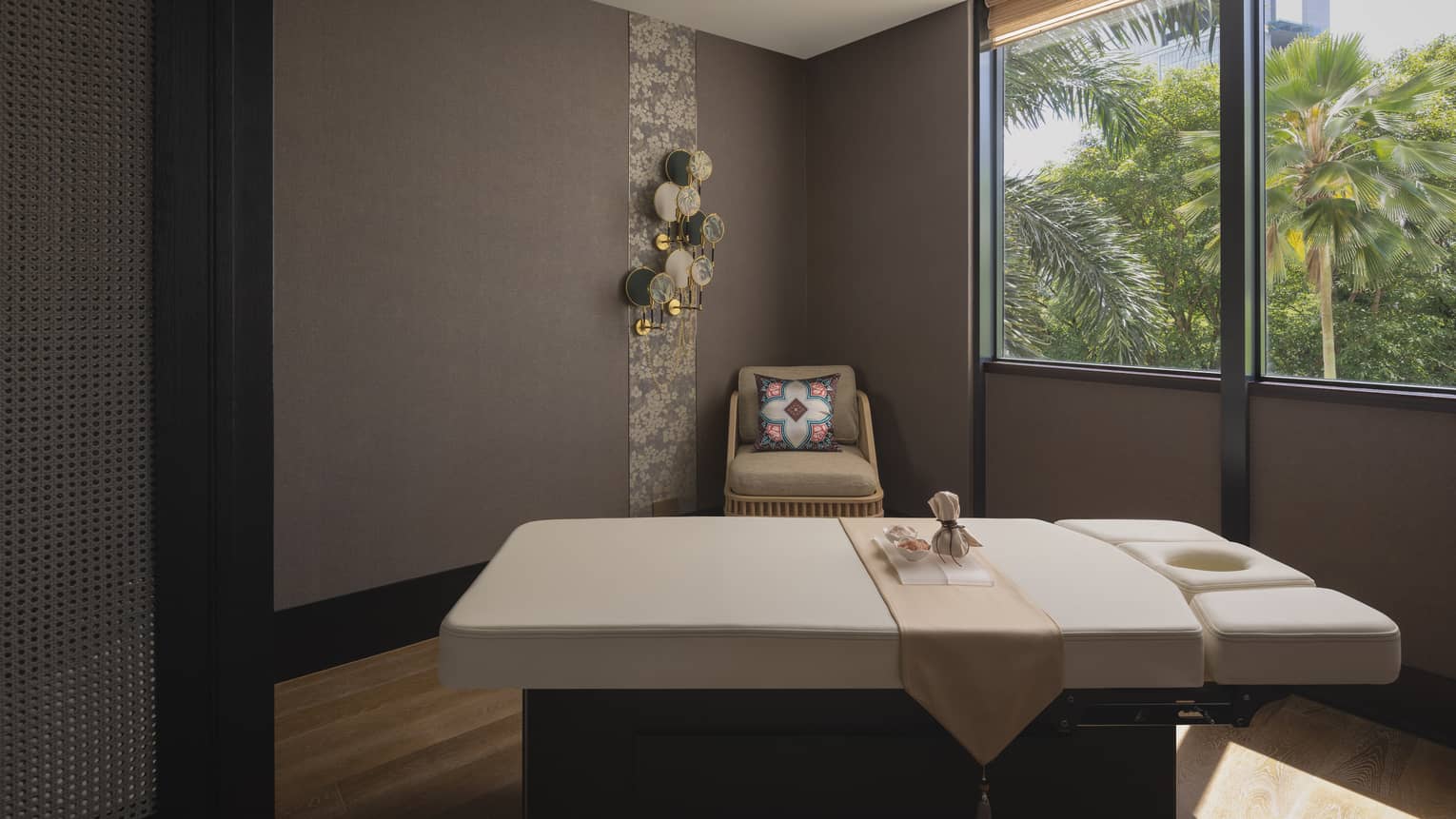 massage table with a view of the jungle outside the window